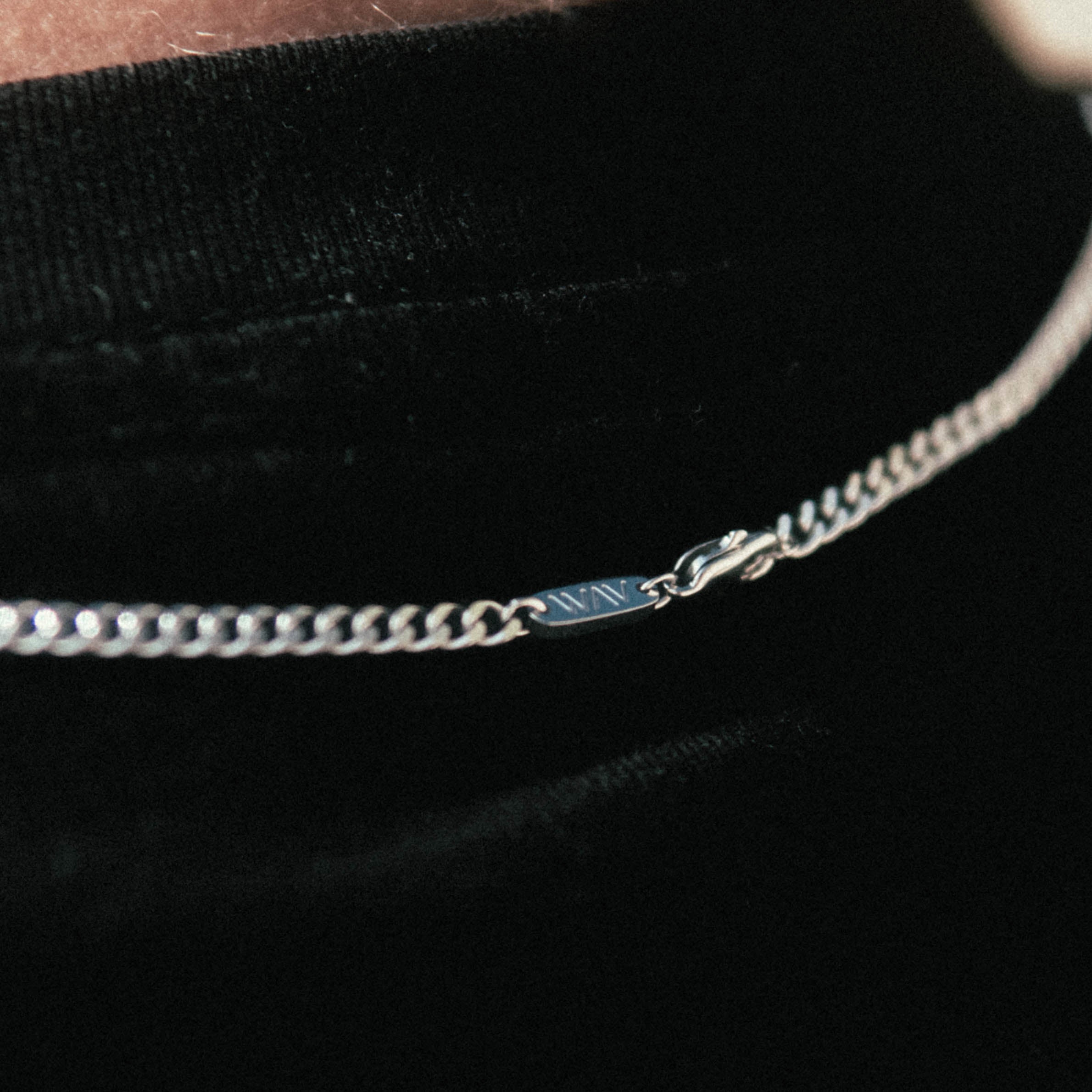 Custom Necklace Ring detail of cuban chain hook on a man's neck, made of stainless steel 316L with 18k gold PVD plating, customized and personalized with Morse code, coordinates, names, initials, dates, or custom text. Minimalist unisex jewelry, shoot on a beach in Portugal, Adraga.