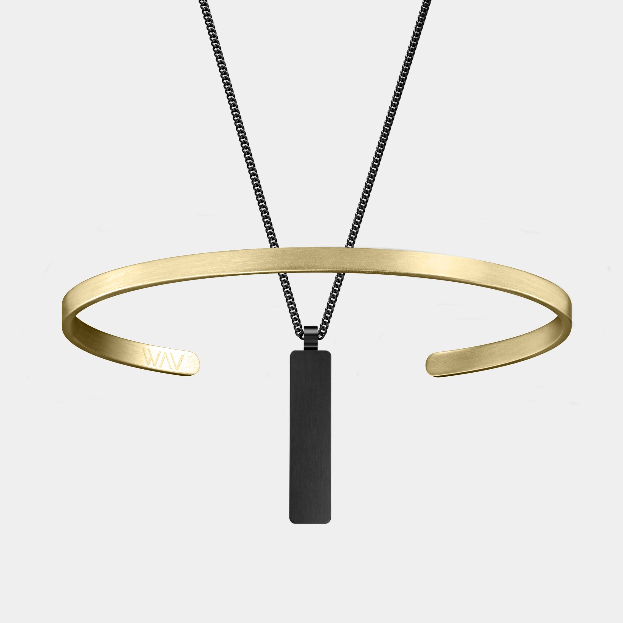 The Custom Cuff + Necklace Bundle by WAV makes a stunning jewelry gift, featuring a gold open cuff bracelet with WAV initials and a black rectangular pendant necklace, elegantly showcased on a plain white background.