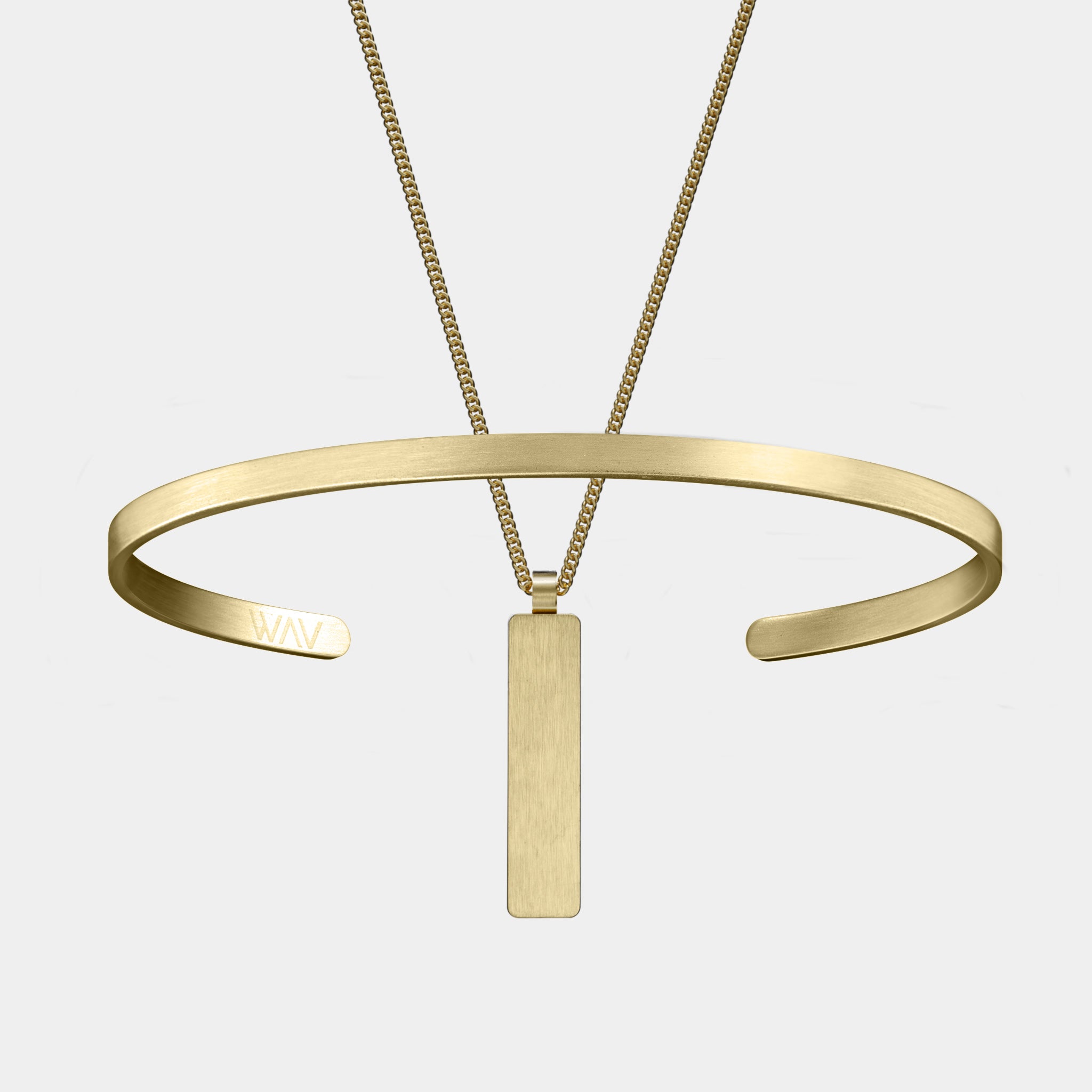 The Custom Cuff + Necklace Bundle by WAV is ideal for those who love personalized jewelry, featuring a minimalist gold necklace with a vertical rectangular pendant and an open bangle engraved with WAV for subtle shine.