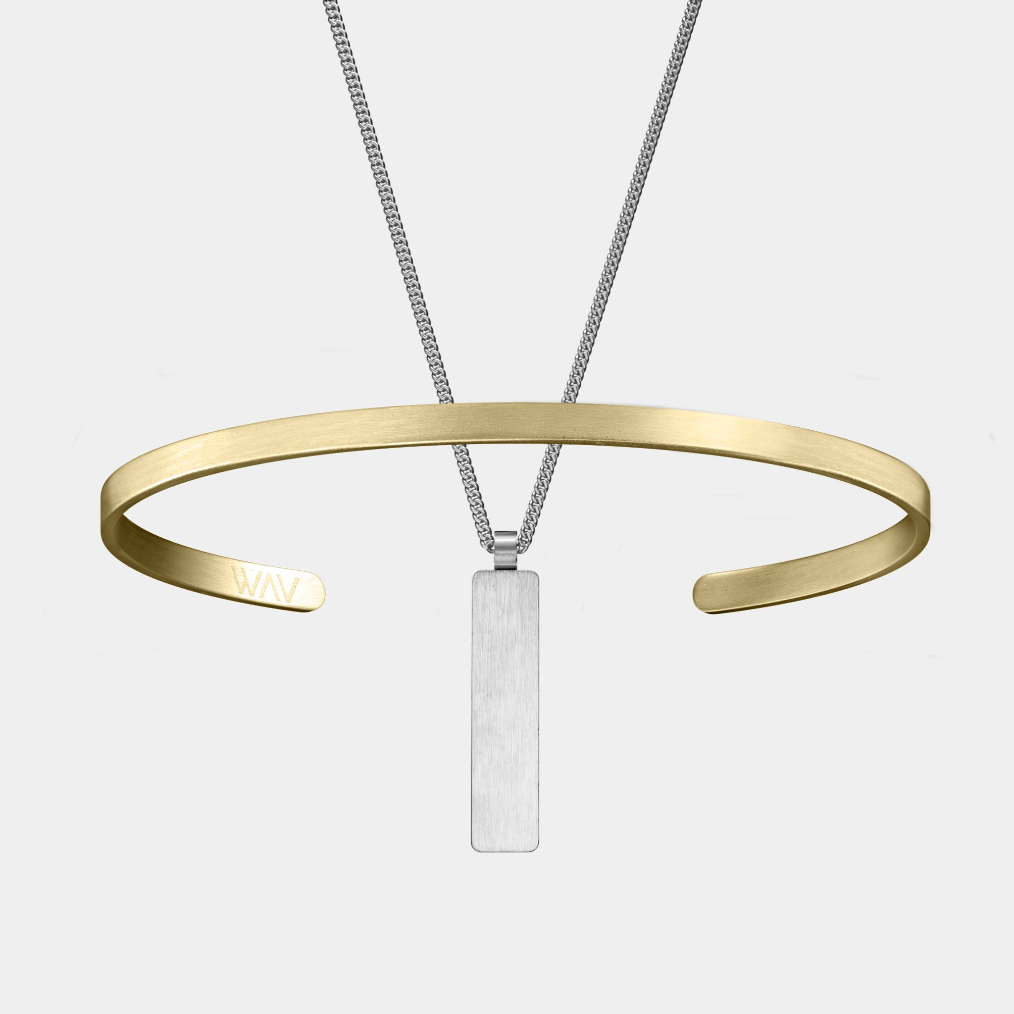 A minimalist image features the WAV Custom Cuff, a slim gold bracelet with an open design, and a custom necklace with a silver rectangular pendant. Set against a solid light gray backdrop, these pieces highlight the essence of personalized jewelry.
