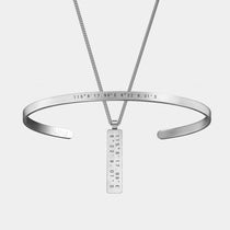 The WAV Custom Cuff + Necklace Bundle includes a silver cuff bracelet and rectangular pendant necklace, both featuring engraved coordinates 115°817.99\E 8°229.01\S. The bracelet is personalized with WAV at the end.