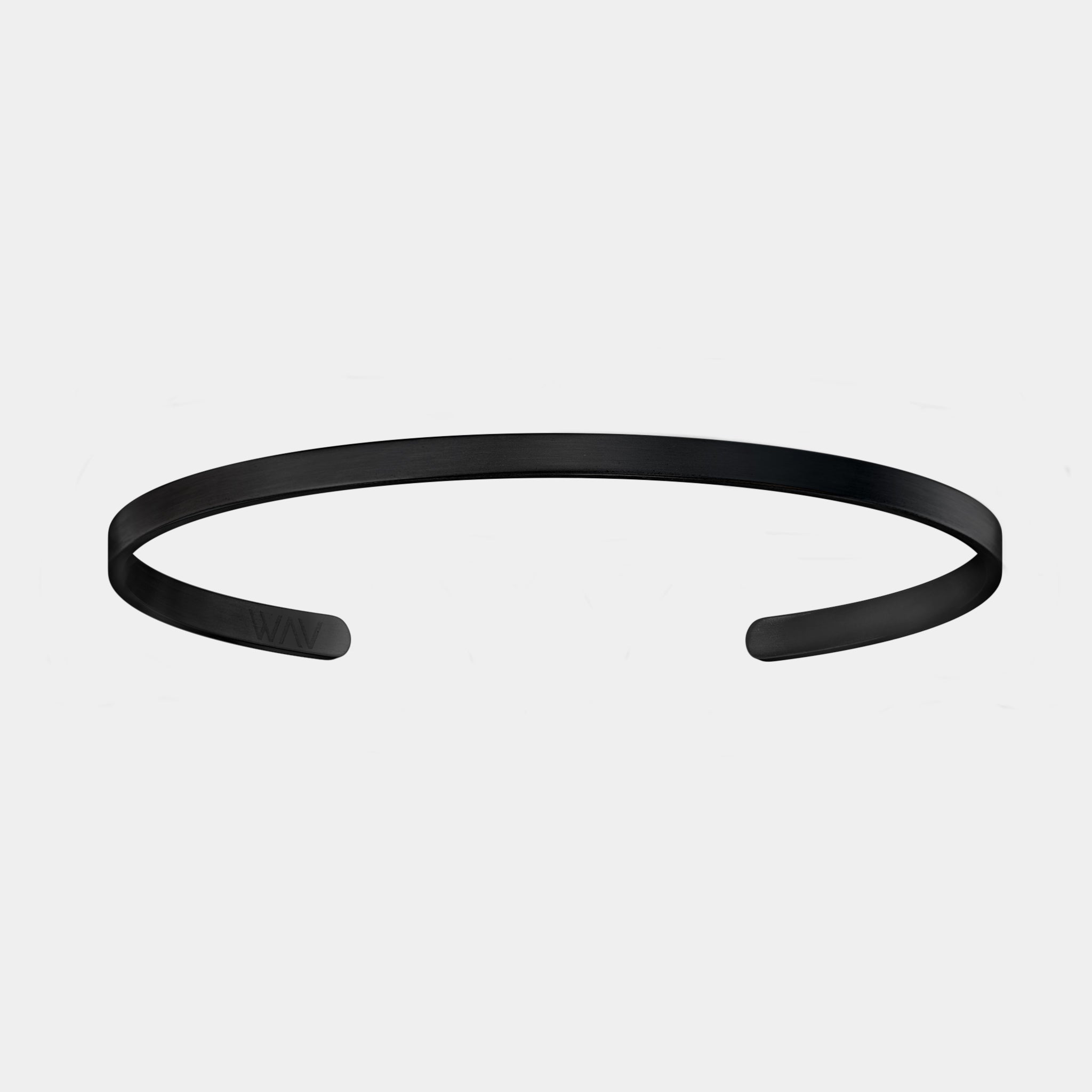 The WAV Custom Cuff Bracelet is a sleek, minimalist black metal piece featuring an open-ended design and slight curve, set against a light gray background.
