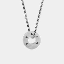 The WAV Custom Necklace Ring is a silver necklace with a pendant engraved with BELLA, showcasing custom jewelry. It has a cut-out circle center and hangs from a classic link chain, highlighted against the light gray background as a beautiful jewelry gift.